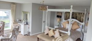 a bedroom with a white canopy bed and a chair at Stella Maris Luxury Bed and Breakfast in Keel