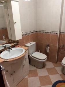 uma casa de banho com um WC, um lavatório e um espelho. em S lazaro em Noya