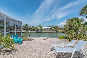 a group of chairs sitting next to a pool at Mermaid Manor; Waterfront with Direct Ocean Access and Private Heated Pool in Marco Island