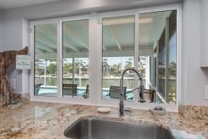 马可岛Mermaid Manor; Waterfront with Direct Ocean Access and Private Heated Pool的带水槽和大窗户的厨房