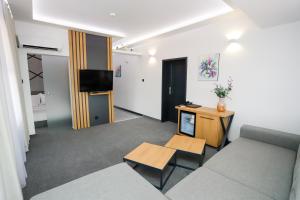 een woonkamer met een bank en een tv bij Glavatarski Han in Glavatartsi