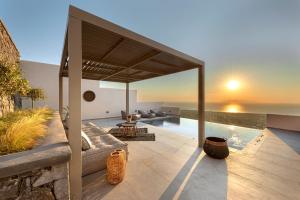an outdoor patio with a couch and a swimming pool at Eolia Luxury Villas in Pirgos
