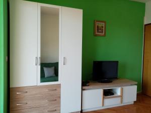 una camera da letto con specchio e TV su un armadio di Apartman Violeta a Lovran (Laurana)