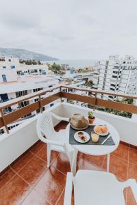 - un balcon avec une table et de la nourriture dans l'établissement Casa Branca Apartments by Wanderlust Madeira, vacation rentals, à Funchal