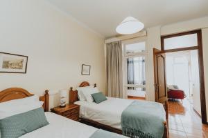 フンシャルにあるCasa Branca Apartments by Wanderlust Madeira, vacation rentalsのベッド2台と窓が備わるホテルルームです。