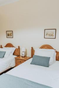 two beds in a bedroom with white sheets and blue pillows at Casa Branca Apartments by Wanderlust Madeira, vacation rentals in Funchal
