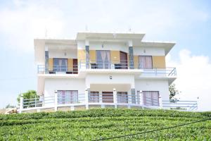 a white building on top of a green hill at VAGAMON GREEN HAVEN RESORT in Vagamon