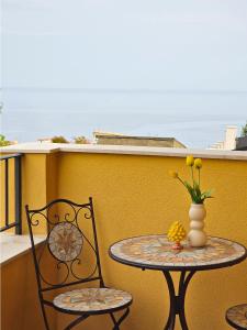 a table and chairs on a balcony with a vase of flowers at Agriturismo Bella Vista - Da Carmelo in Santa Teresa di Riva +39 photos