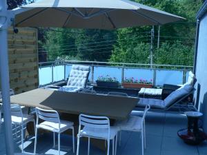 een patio met een tafel en stoelen en een parasol bij liège 4420 rue jean Jaurès 45 grande maison joyeuse avec terrasse 30m2 pour 8 personnes maximum in Saint-Nicolas