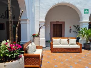 Hotel Catedral في كويرنافاكا: غرفة معيشة بها أريكة وكراسي وورود