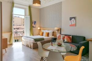 a living room filled with furniture and a window at Ajoupa Aparthotel AMMI Massena in Nice