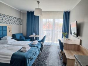 a hotel room with a large bed and a desk and a desk at Cesarskie ogrody 102A By Edyta in Świnoujście