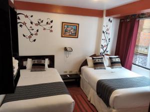 ein Hotelzimmer mit zwei Betten und einem Fenster in der Unterkunft Inkas Land in Machu Picchu