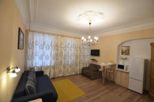 sala de estar con sofá, mesa y cocina en Apartment on Dmitrovskiy 7, en San Petersburgo
