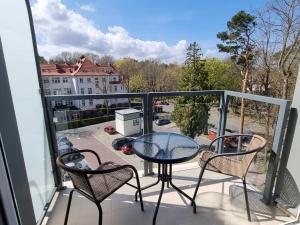 a balcony with a table and chairs and a view at Cesarskie ogrody 102A By Edyta in Świnoujście