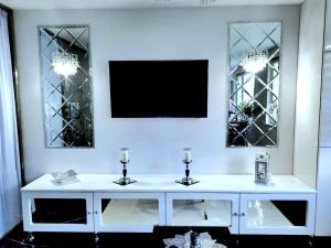 un tavolo bianco con due candele e due specchi di Apartament Glamour a Gniezno