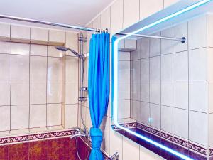 a shower with a blue shower curtain in a bathroom at Apartments Sandra in the historical center of the city in Supetar +85 photos