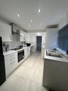 a large kitchen with white cabinets and appliances at New modern Private House central location in Newcastle upon Tyne