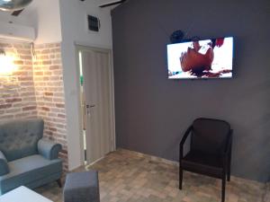sala de estar con sofá y TV en la pared en Budva stan Natasa en Budva