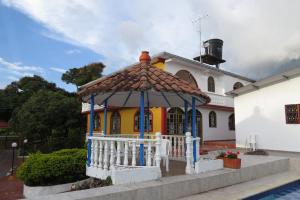 uma casa com um gazebo em frente em Finca Las Mercedes en encantador entorno natural em El Triunfo