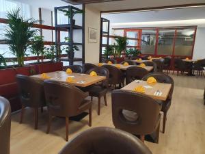 una sala da pranzo con tavoli, sedie e finestre di Ubytování Hanka v hotelovém pokoji C408 a Frymburk
