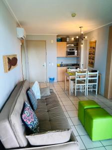 ein Wohnzimmer mit Couch und Küche in der Unterkunft Beach Class Slin Muro Alto in Porto De Galinhas