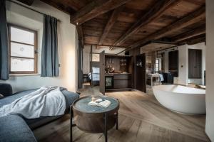 a bedroom with a bed and a bath tub at Hotel Ansitz Steinbock in Villandro