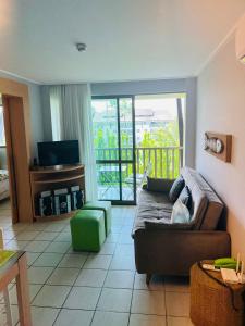 ein Wohnzimmer mit Sofa und Fernseher in der Unterkunft Beach Class Slin Muro Alto in Porto De Galinhas