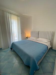 um quarto com uma cama grande e um cobertor azul em SunSea Apartments Pisciotta em Pisciotta