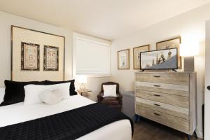 a bedroom with a bed and a dresser with a television at Snowmass Mountain by Snowmass Vacations in Snowmass Village