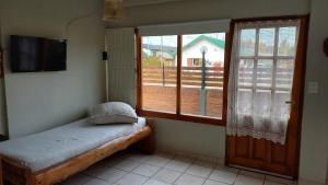 a room with a small bed and a window at ROCA AZUL in El Bolsón