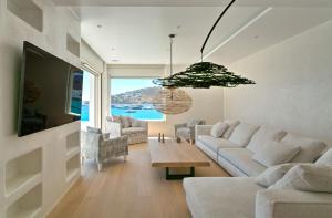a living room with a couch and a table at The Absolute beachfront luxury villa in Platis Yialos Mykonos