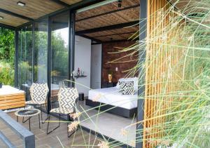 亚美尼亚Panorama Pueblo Tapao的庭院里设有一张床和椅子的房间