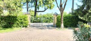 a gate in a brick driveway with a tree at L'incanto home in Bologna