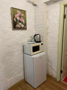 a microwave sitting on top of a refrigerator at Andreevskiy mini-hotel in Kyiv +11 photos