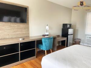 a bedroom with a desk with a television and a bed at Kings Arms Motel in Ocean City