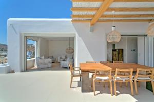a dining room with a wooden table and chairs at The Absolute beachfront luxury villa in Platis Yialos Mykonos