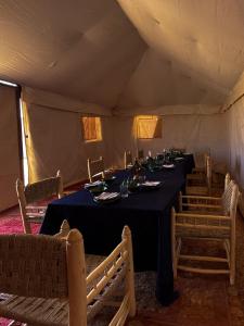 a dining room in a tent with a table and chairs at Bivouac Les Nomades & Foum zguid to chegaga tours in Foum Zguid
