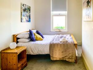 a bedroom with a bed with a table and a window at Stay In The Heart Of 'Bishy Road' At The Vines With Free Parking - York Holiday Home in York