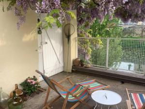 patio ze stołem, krzesłem i stołem w obiekcie Agréable petite maison située au bord du Doubs w mieście Verdun-sur-le-Doubs