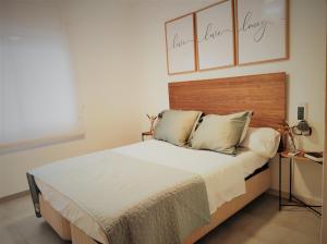 Schlafzimmer mit einem großen Bett mit einem Kopfteil aus Holz in der Unterkunft Lovely apartment in Calafell