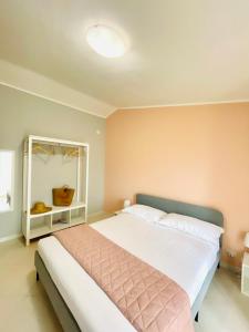 ein Schlafzimmer mit einem großen Bett mit einer rosa Wand in der Unterkunft Sicily Emotion in Giardini-Naxos