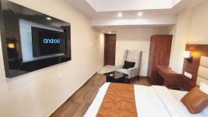 um quarto de hotel com uma cama e uma televisão de ecrã plano em Hotel BlueArk em Lucknow