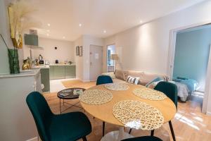 Le Casa-blanca Magnifique Appartement chic&cosy في كولوبريير: مطبخ وغرفة معيشة مع طاولة وكراسي