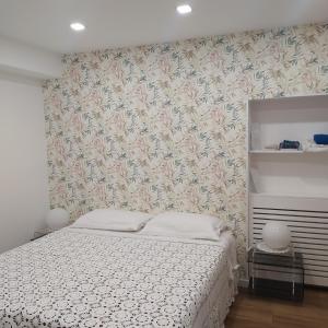 Torricella Peligna的住宿－la Casa sul Corso -- alloggio turistico -- appartamento open space，一间卧室配有一张带花卉壁纸的床