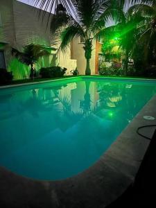 a large swimming pool with green lights in a house at New Home Sol, Mar y Arena Ixtapa. in Ixtapa
