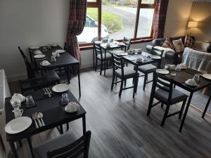 a restaurant with tables and chairs and a couch at The Thistle Guest Rooms in Portree
