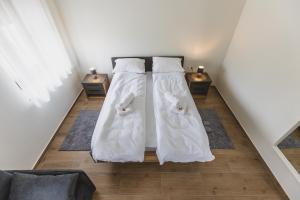 2 camas blancas sentadas en el suelo en una habitación en Vila Guliver en Palić