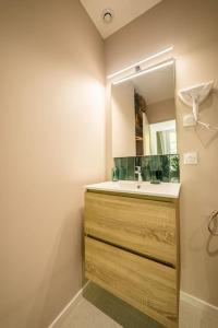 Le Pearl Appartement de charme en bord rivière في كولوبريير: حمام مع حوض ومرآة