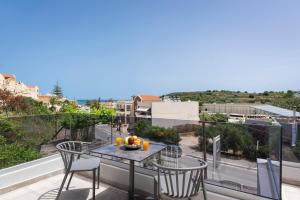 a table and chairs on a balcony with a view of a street at Aequor Luxury Rooms & Apartments in Kato Daratso